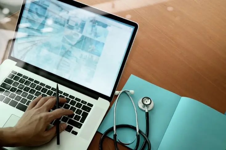 top view of Medicine doctor hand working with modern computer and smart phone on wooden desk as medical concept (1)